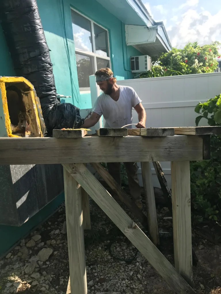 Technician building a raised platform for an air handler and new ductwork at a Cocoa home