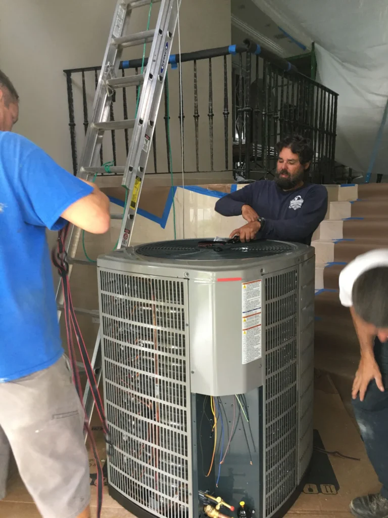 Cool Aid install crew wiring a new condenser during a home renovation